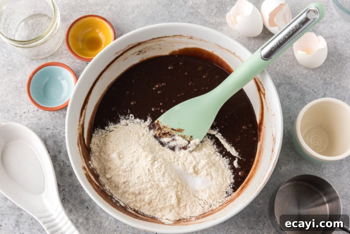 Deep Dish Peanut Butter Brownie 10 dry ingredients added to a bowl of brownie batter with a rubber spatula