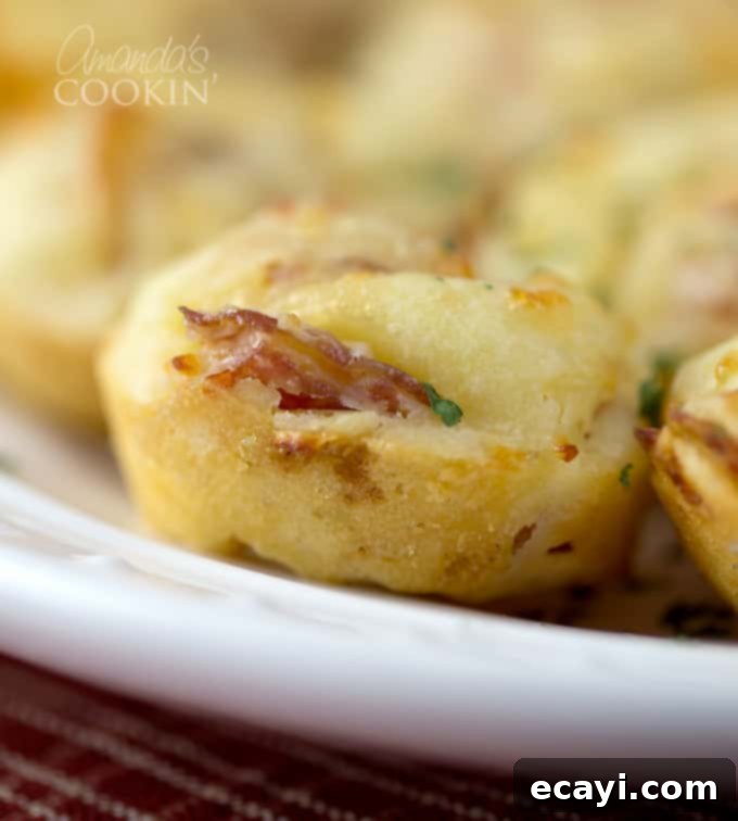 Cheesy Pepperoni Pizza Bites 4 A single, perfectly baked pepperoni pizza puff, golden and inviting, resting on a white plate.