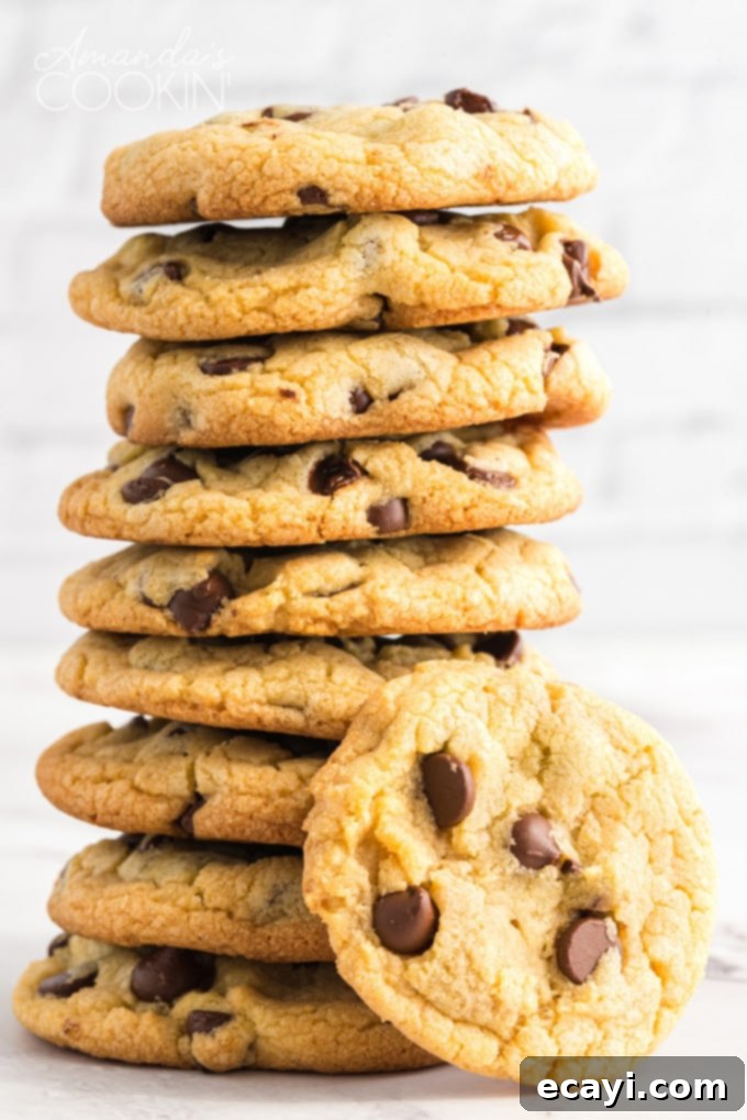 These Chocolate Chip Pudding Cookies are exceptionally soft, chewy, and always a hit. Easy to make with instant pudding, you can even freeze the dough to bake later! tall stack of incredibly soft and chewy Chocolate Chip Pudding Cookies with melty chocolate chips