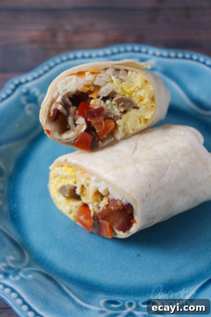 Sunrise Burritos 2 A close-up of a breakfast burrito cut in half on a blue plate, revealing eggs, cheese, and bacon inside.