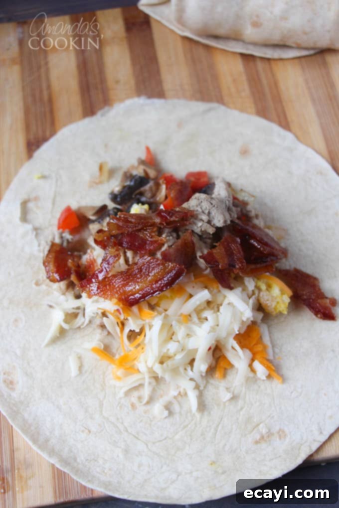 Sunrise Burritos 4 An overhead view of an open flour tortilla on a wooden cutting board, filled with scrambled eggs, bacon, and shredded cheese.