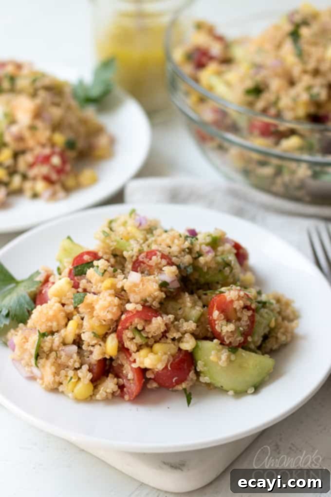 This summer vegetable quinoa salad is bursting with flavor! A vibrant bowl of Summer Vegetable Quinoa Salad, showcasing colorful vegetables and fluffy quinoa on a rustic plate.