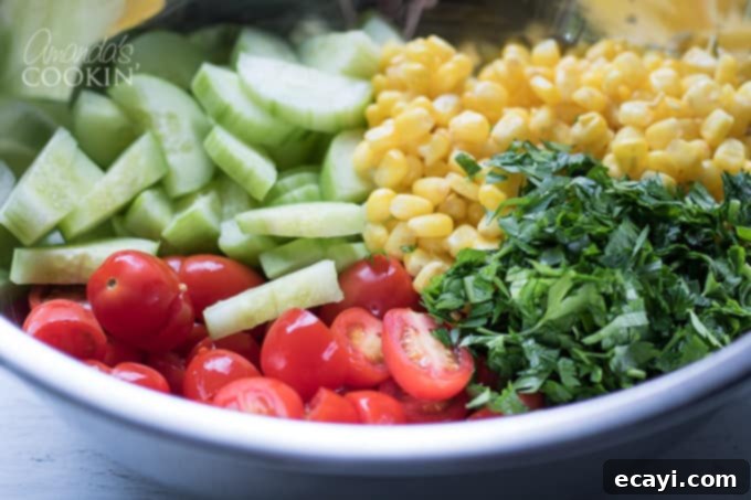 Garden Fresh Summer Quinoa Delight 4 Freshly chopped corn, cucumber, tomatoes, cheese, red onion, and parsley combined in a large mixing bowl for the quinoa salad.