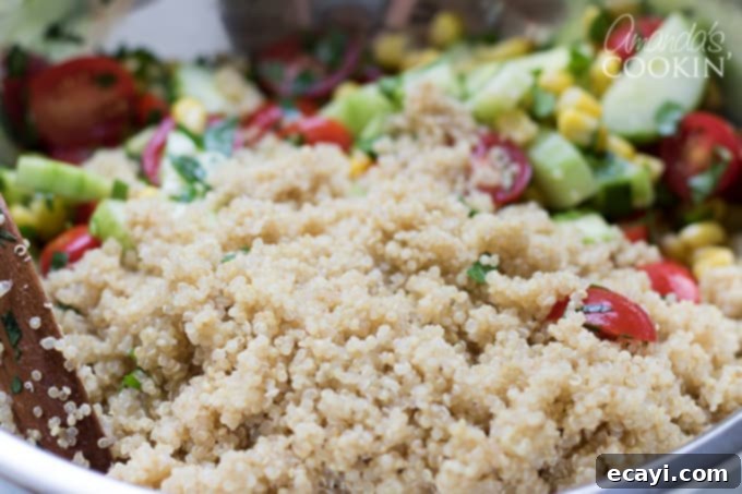 Garden Fresh Summer Quinoa Delight 6 Adding the cooled cooked quinoa to the bowl of mixed summer vegetables, preparing for the final toss.