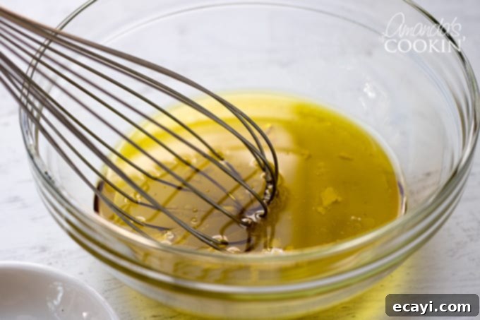 Garden Fresh Summer Quinoa Delight 8 Whisking together the dressing ingredients – olive oil, vinegars, and mayonnaise – in a bowl for the summer vegetable quinoa salad.