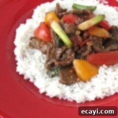 Zesty Beef, Tomato, and Bell Pepper Stir-Fry 4 A photo of hearty beef stir fry with tomatoes and peppers served over fluffy white rice.