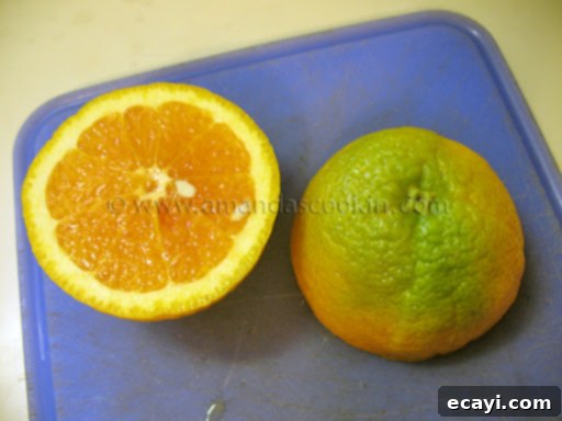Creamy Orange Bliss 4 A close-up photo of a Sunkist Valencia orange sliced perfectly in half, revealing its vibrant, juicy, and fully ripe orange interior, contrasting with its partially green exterior.
