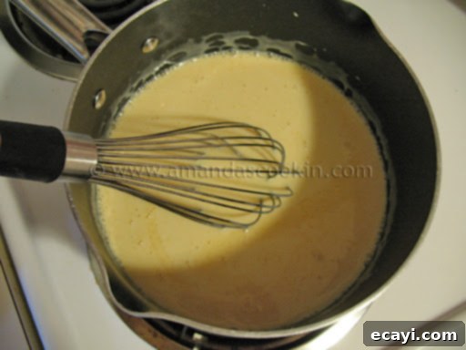 Creamy Orange Bliss 7 An overhead photo of sweetened condensed milk and freshly squeezed orange juice combined in a heavy-bottomed saucepan, ready for cooking.
