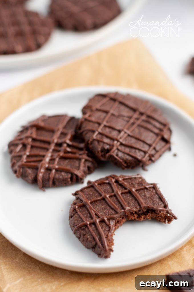Chocolate mint cookies with pretty chocolate drizzles are easy to make and are great for Christmas cookie exchanges! Soft, chewy, and minty! chocolate mint cookies on plate with a bite out of it