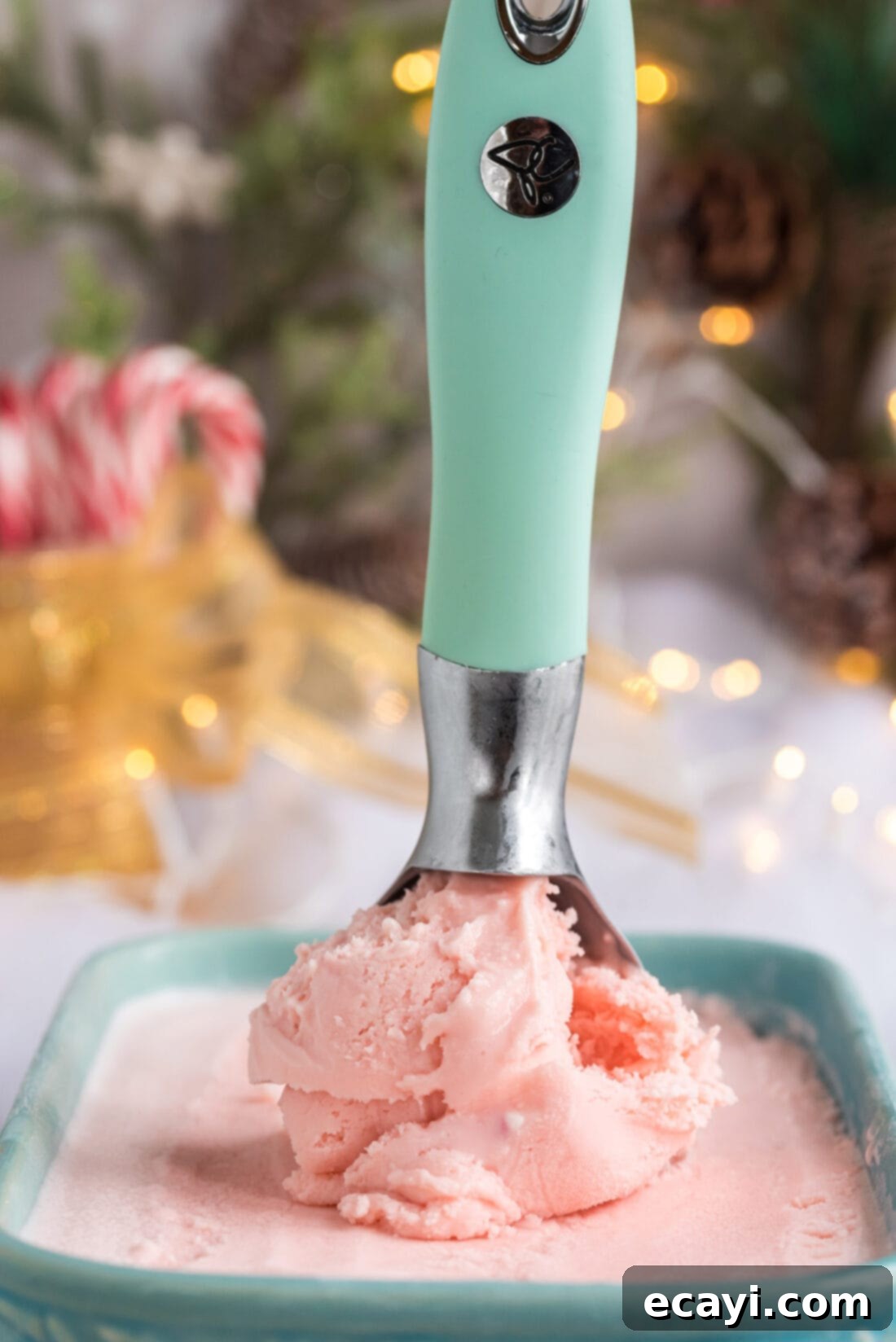 Cool Peppermint Bliss 10 Scoop of Homemade Peppermint Ice Cream in an ice cream scoop resting in a container of Homemade Peppermint Ice Cream