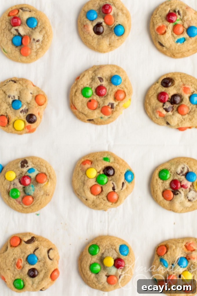 A tray of freshly baked, perfectly golden Chocolate Chip M&M Cookies, ready to be enjoyed. A baking tray filled with perfectly golden brown M&M chocolate chip cookies, fresh from the oven and cooling.