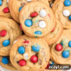 Colorful M&M Chocolate Chip Cookies 3 Red, white, and blue M&M chocolate chip cookies arranged on a plate.