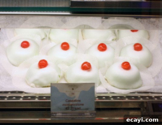 In Catania, there is a small, individual version of the cake that is named in honor of the city’s patron, Saint Agatha (Cassatella di Sant'Agata). The cake is made to resemble a woman’s breast as an allusion to the Saint’s fate: the story relates that her breasts were cut off by a frustrated suitor, who tortured her because she refused his advances. In Catania, the unique individual cake, Cassatella di Sant'Agata, shaped like a woman's breast, honors the city's patron saint and alludes to her tragic fate.
