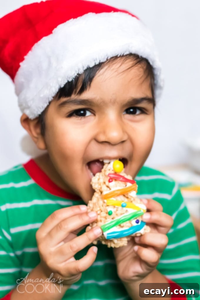 Make Christmas Tree Rice Krispie Treats with the kids. Rice Krispies, marshmallows, and candy decorations make adorable Christmas trees! little boy eating a Christmas Tree Rice Krispie Treat