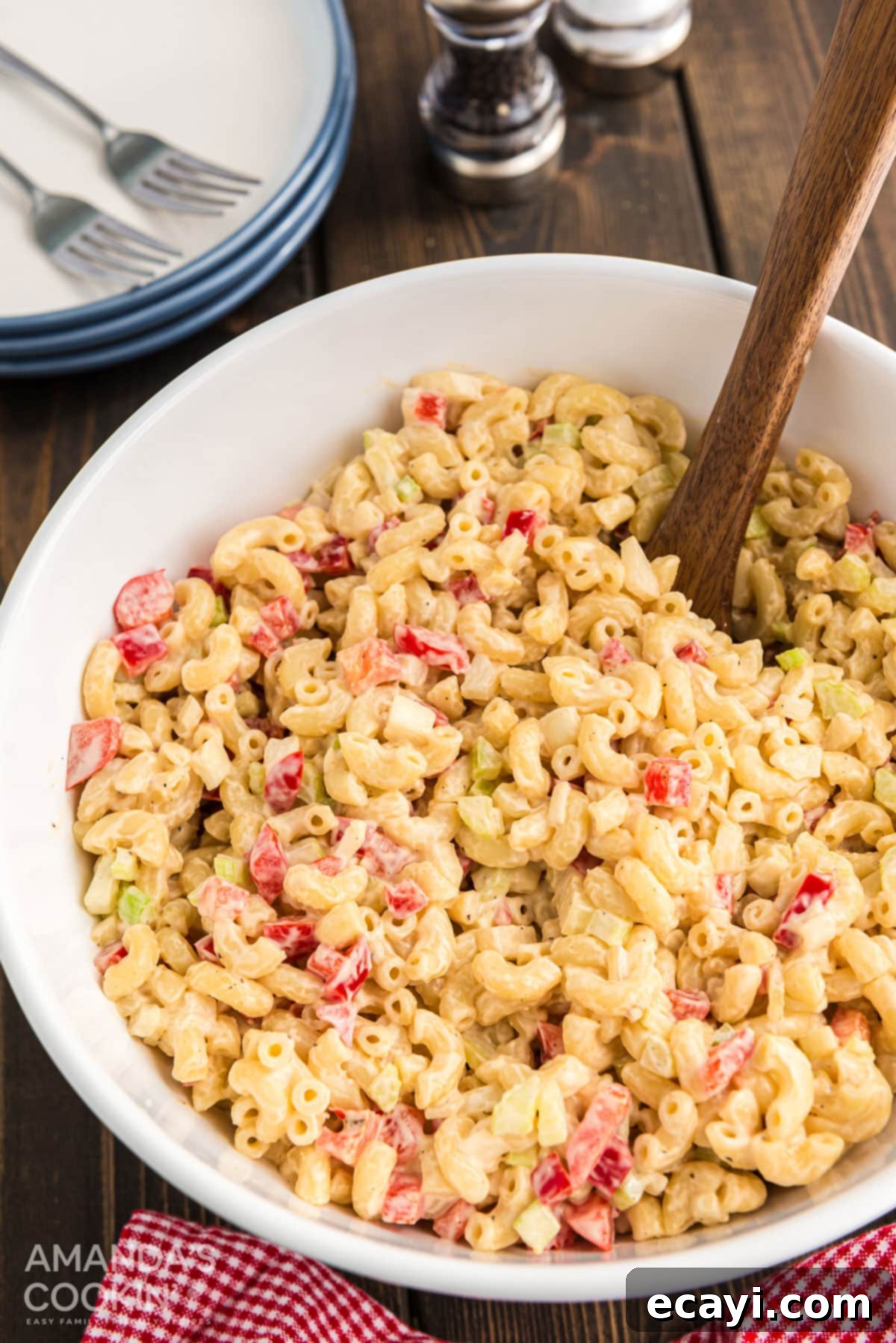 A top-down view of Nana's creamy macaroni salad, ready for serving. A beautifully presented, creamy macaroni salad in a white bowl, viewed from above, garnished lightly.