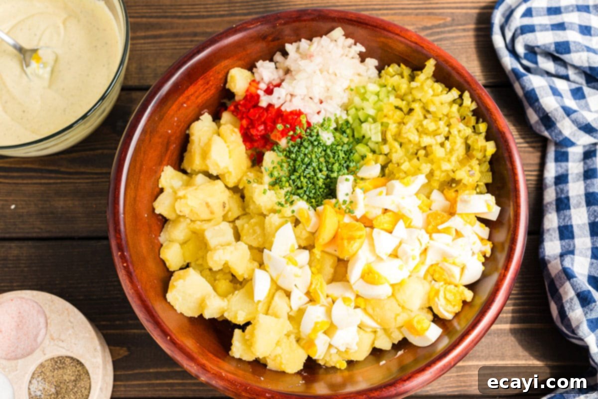 Mom's Classic Potato Salad 6 All diced ingredients for potato salad, including potatoes, eggs, and vegetables, in a large mixing bowl.