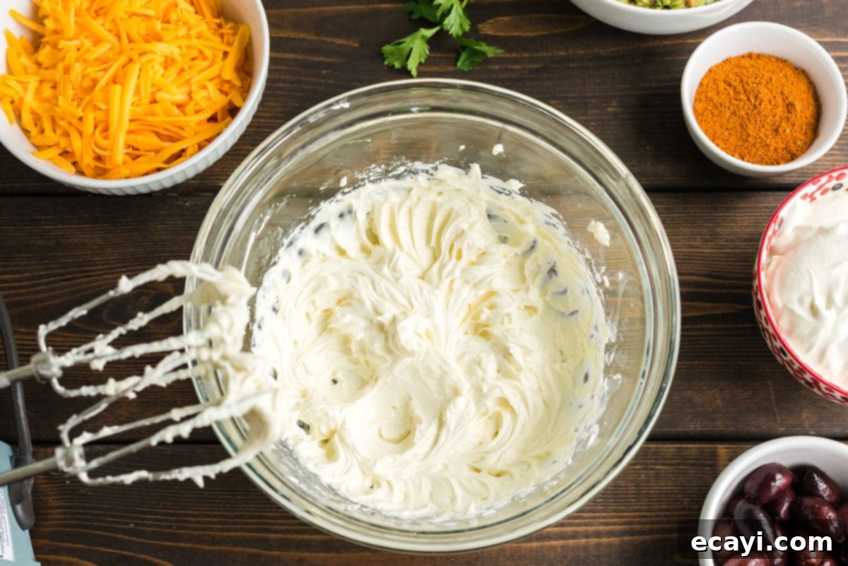 Ultimate Taco Dip 4 Beaten and creamy cream cheese in a mixing bowl, ready for the next ingredients in the taco dip