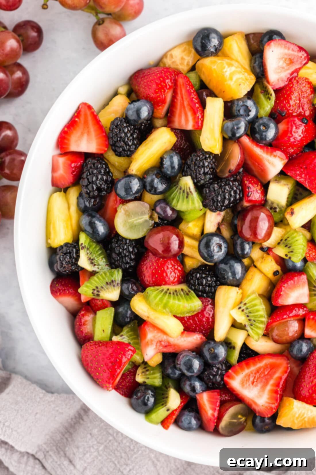 My cousin insists on having fruit salad at every holiday. This is our family's go-to recipe and it's always a favorite. Close-up photo of a bowl of freshly prepared fruit salad, highlighting the vibrant colors and fresh berries.
