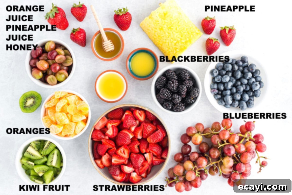 Nature's Sweet Bowl 2 Labeled bowls of prepared ingredients for fruit salad including pineapple, strawberries, kiwi, oranges, grapes, blueberries, and blackberries.