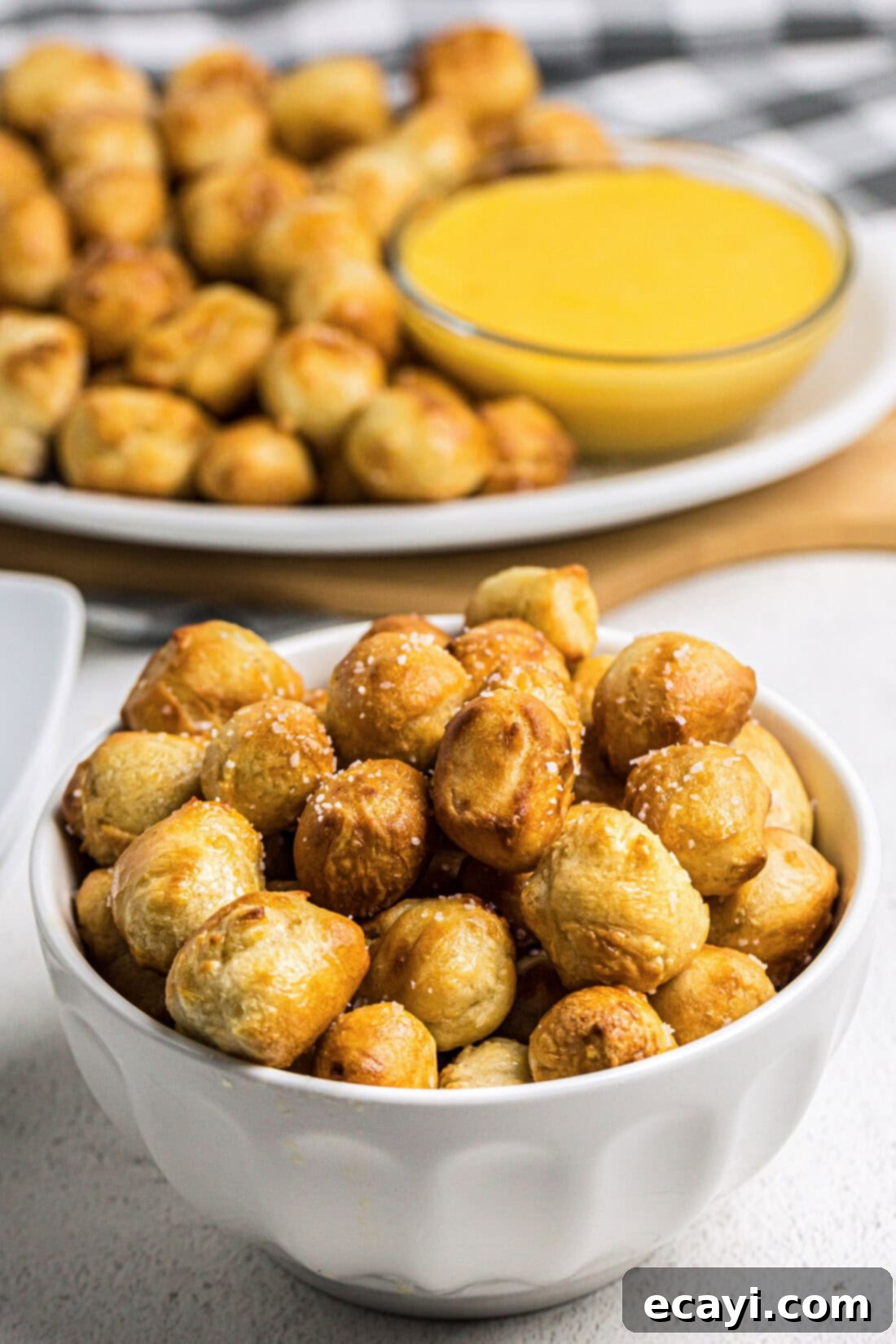 Perfectly Poppable Air Fried Pretzels 2 Bowl of Air Fryer Pretzel Bites with more pretzel bites on a platter in the background