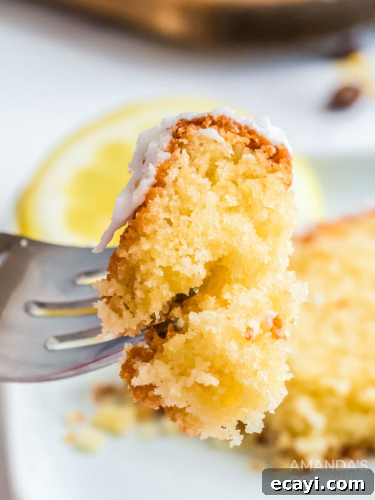 Make the famous Starbucks lemon loaf in your own kitchen. Great for breakfast with coffee, as a snack, or for dessert! fork holding a piece of copycat starbucks lemon loaf