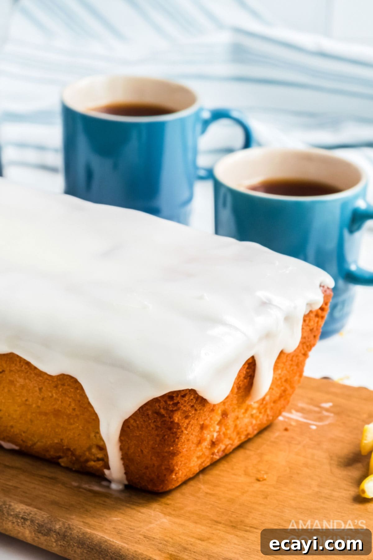Make the famous Starbucks lemon loaf in your own kitchen. Great for breakfast with coffee, as a snack, or for dessert! glazed quick bread with coffee cups in background