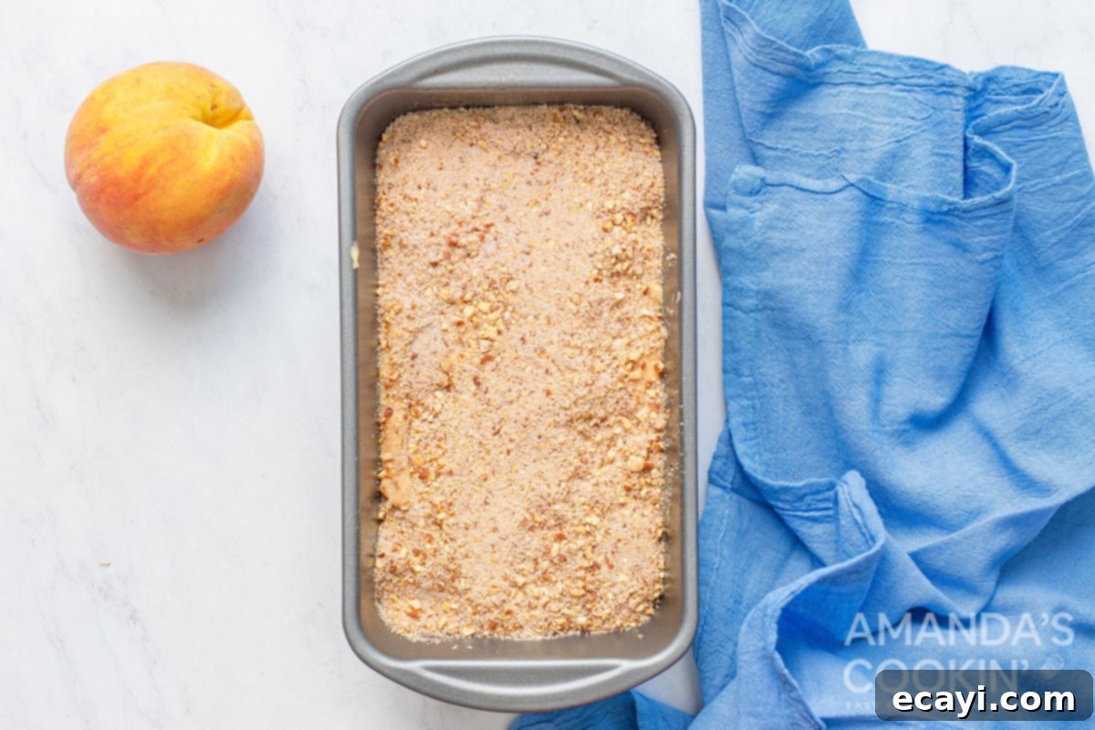 Golden Peach Loaf 6 Peach bread batter in a loaf pan, evenly spread and generously sprinkled with the cinnamon almond topping before baking.