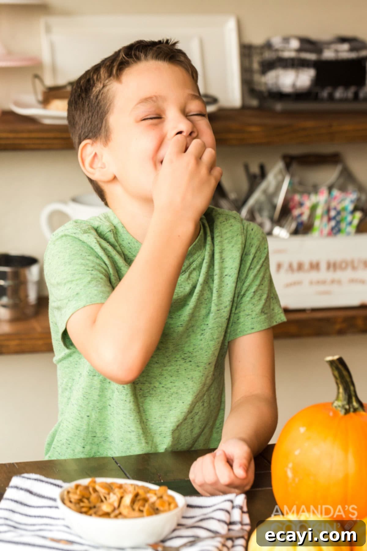 Child happily eating roasted pumpkin seeds A happy child enjoying a handful of freshly roasted pumpkin seeds as a healthy fall snack.