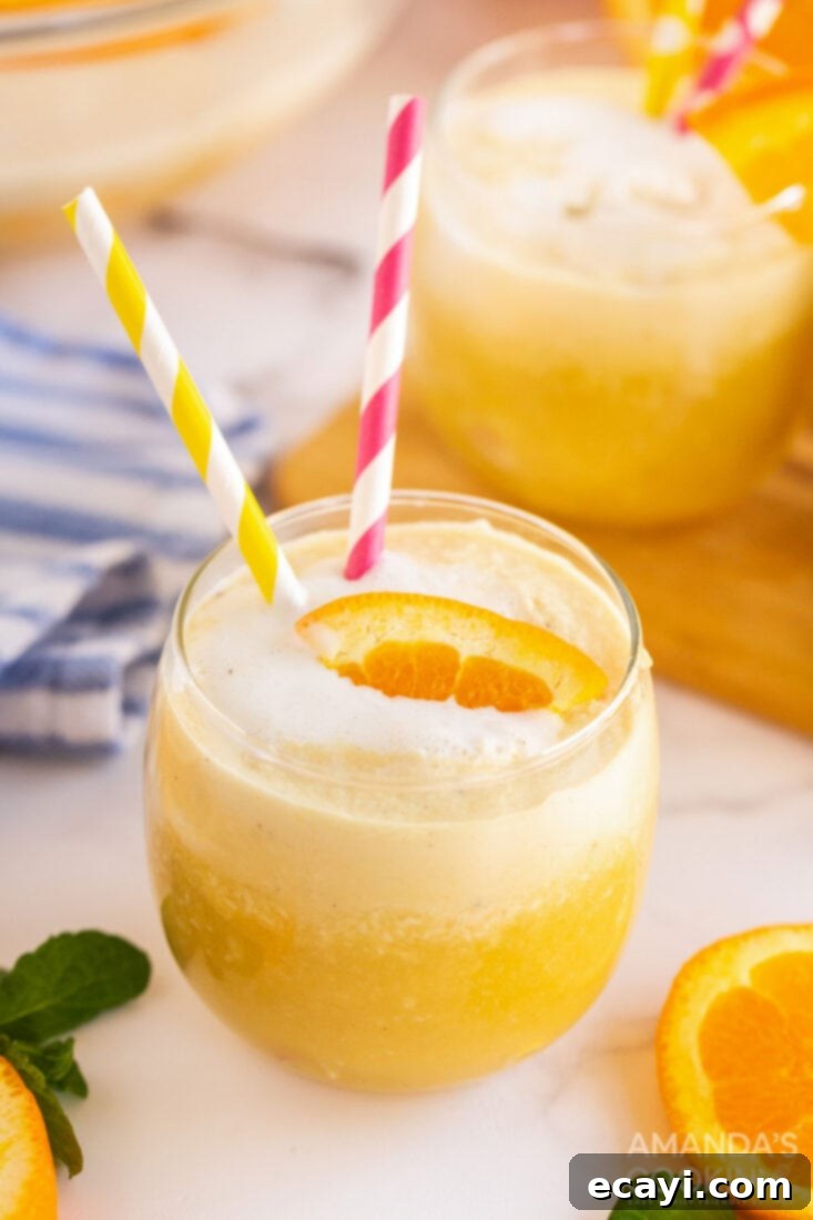 With only four ingredients you can make this creamy, dreamy, vanilla orange punch. Whether it's in the fall, summer, or spring, it's delicious year-round! Two glasses of creamy vanilla orange punch with decorative straws, ready to be enjoyed