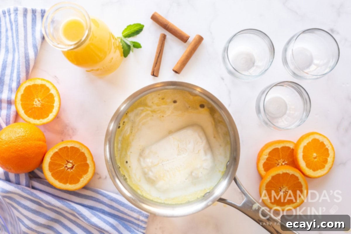 Velvet Orange Vanilla Punch 4 Vanilla ice cream melting and stirring into the warm orange juice mixture in a saucepan