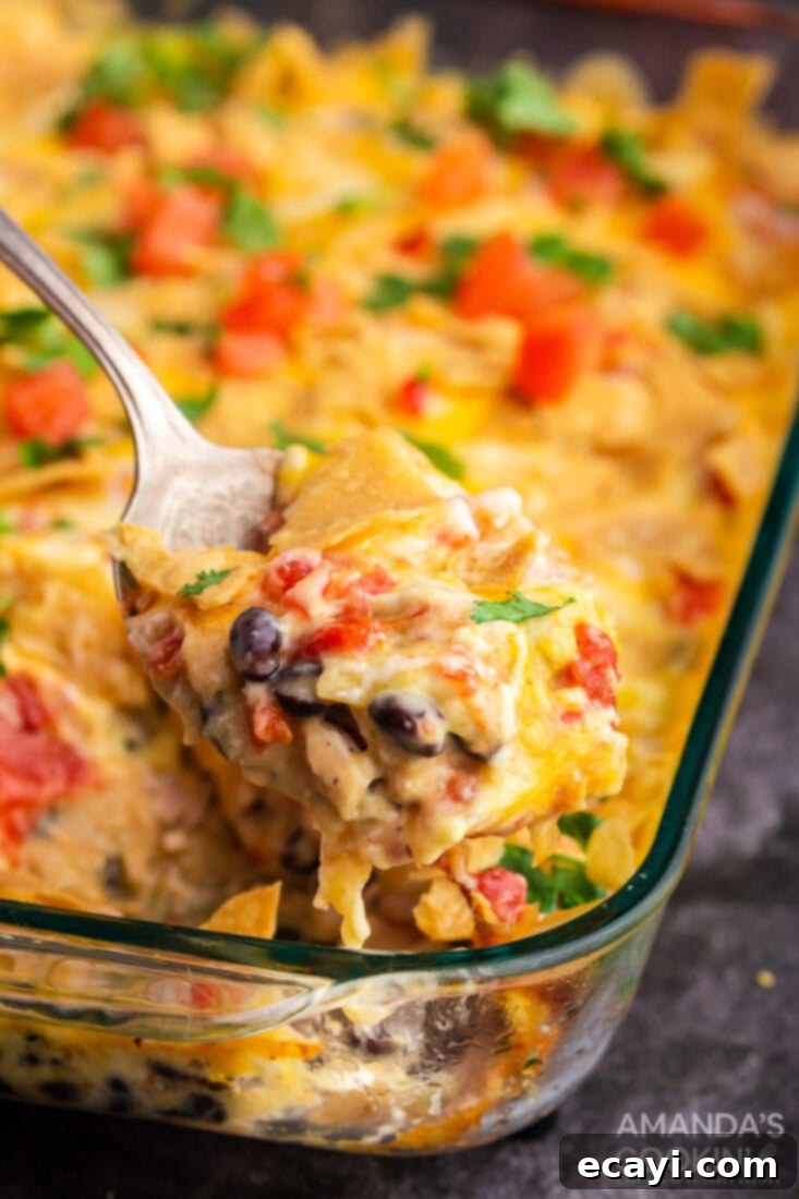 Quick and easy Mexican Chicken Casserole, a delightful family meal Spoon lifting a warm, cheesy serving of Mexican Chicken Casserole from the dish