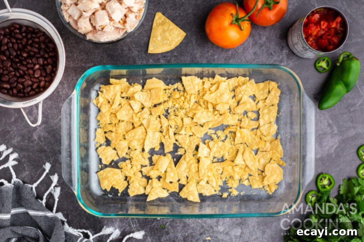 Fiesta Chicken Bake 3 First layer of lightly crushed tortilla chips at the bottom of a casserole dish