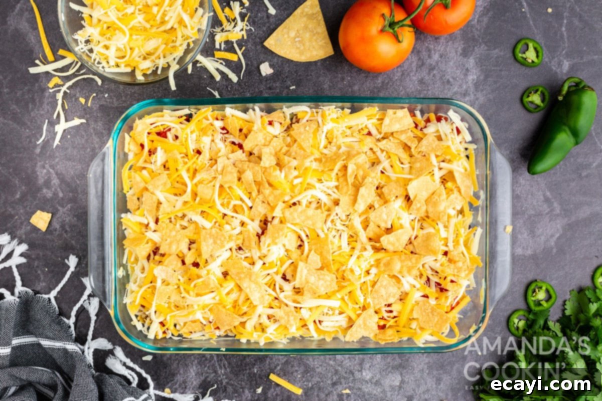 Fiesta Chicken Bake 6 Final layers of shredded cheese and crushed chips ready for baking in the casserole