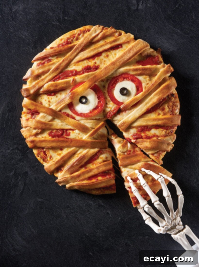 Monster Munchies 4 Close-up of a delicious mummy pizza with olive eyes and cheese strip bandages