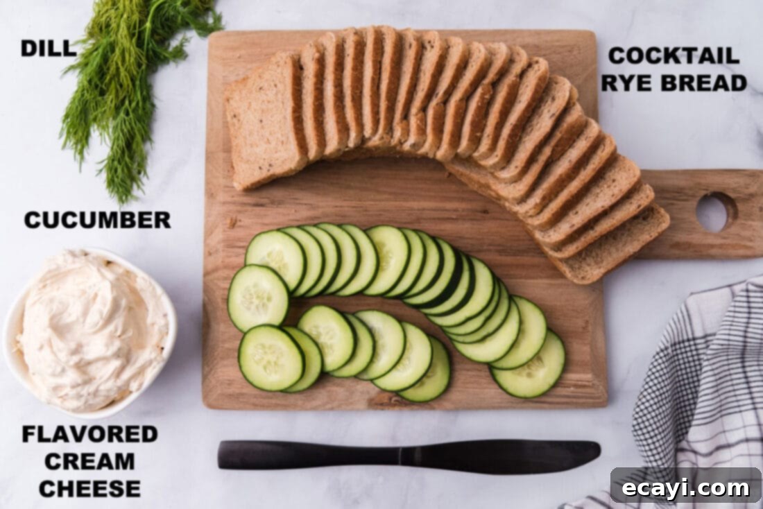 Delicate Cucumber Finger Sandwiches 4 A flat lay photograph displaying all the labeled fresh ingredients required for making mini cucumber sandwiches, including bread, cream cheese, cucumber, and dill.