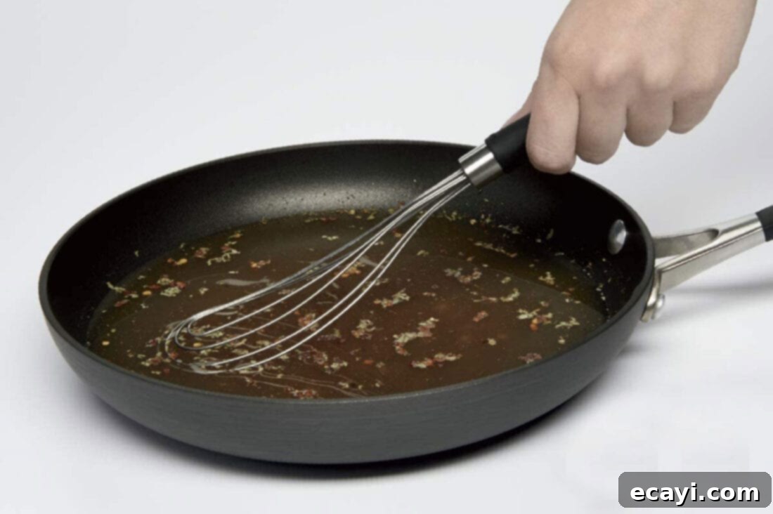 21 Kitchen Gadgets You'll Reach For Daily 14 A flat wire whisk mixing ingredients in a frying pan, highlighting its ability to reach corners and prevent sticking.