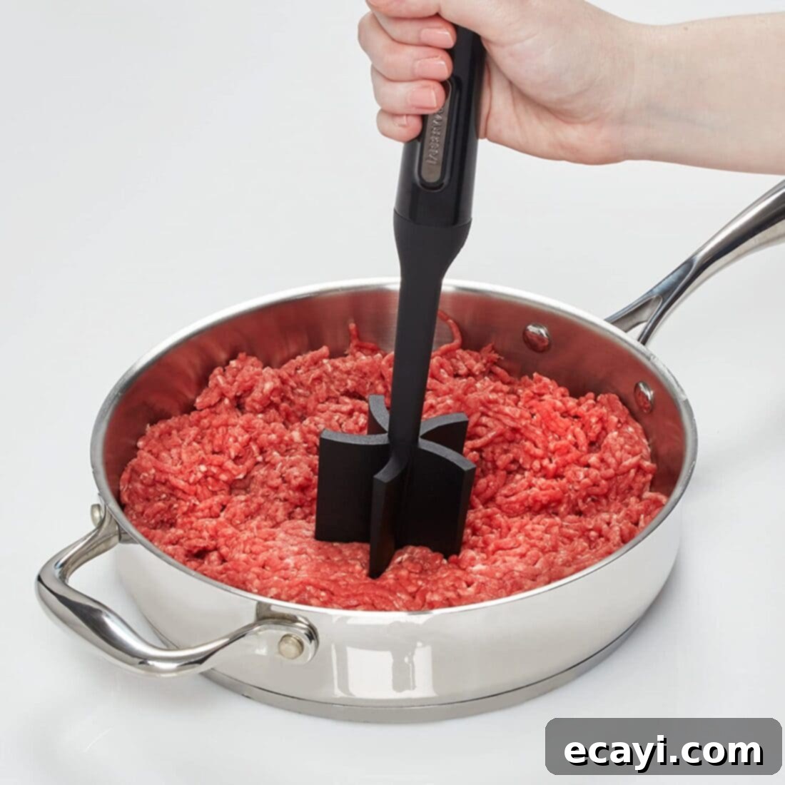 21 Kitchen Gadgets You'll Reach For Daily 15 A meat/potato masher expertly mashing ground beef in a skillet, demonstrating its efficiency in breaking up meat.