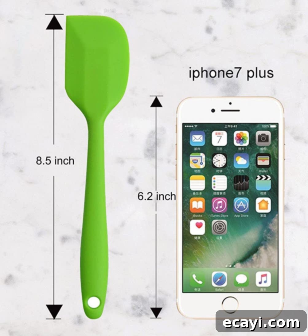 21 Kitchen Gadgets You'll Reach For Daily 16 A small rubber spatula rests beside a smartphone, highlighting its compact and versatile size for various kitchen tasks.
