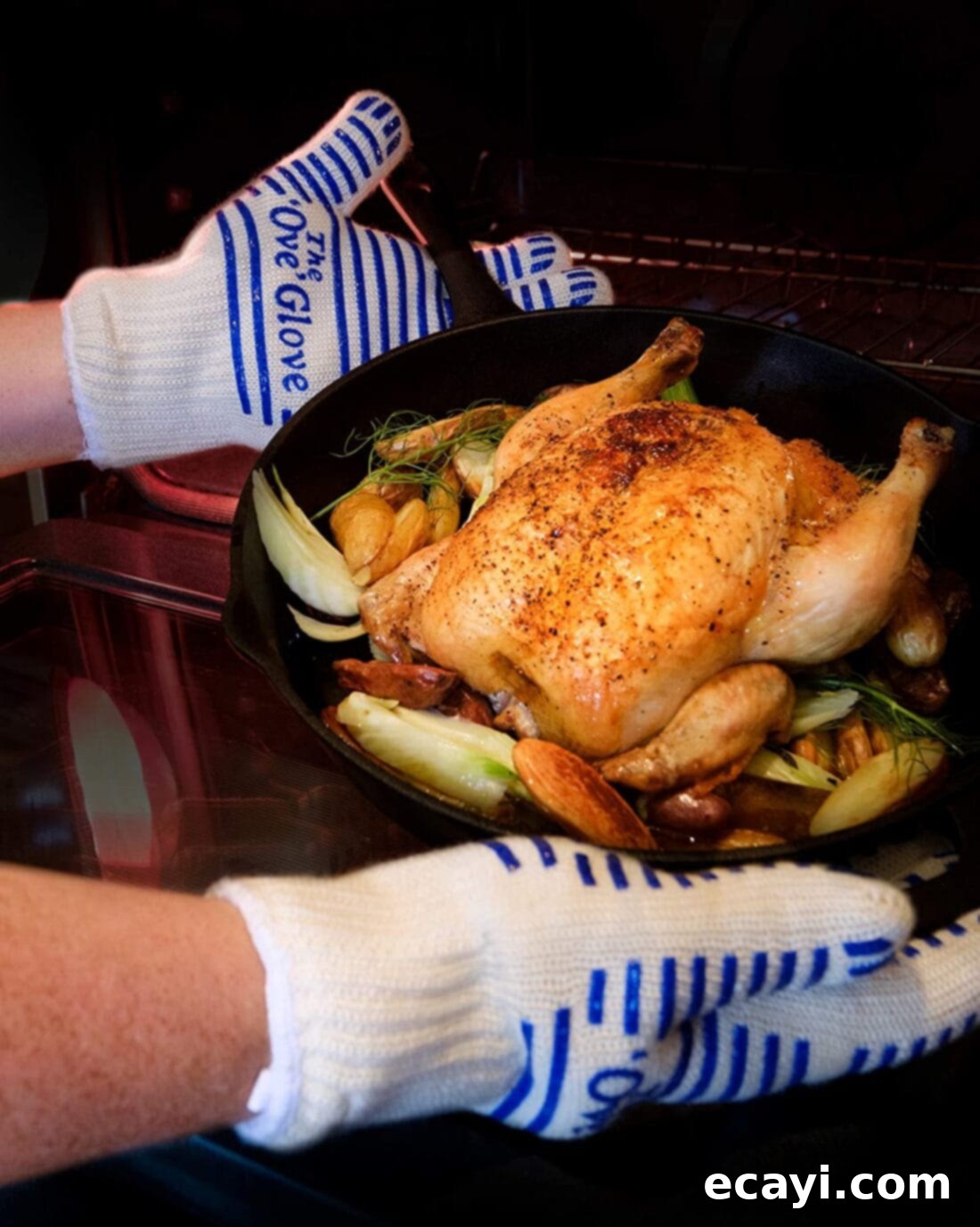 21 Kitchen Gadgets You'll Reach For Daily 18 A hand wearing an Ove Glove safely removing a tray of roasted chicken from a hot oven, highlighting its protective and flexible design.