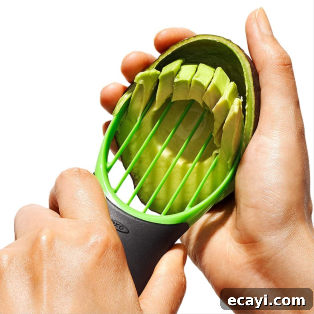 21 Kitchen Gadgets You'll Reach For Daily 5 A hand skillfully uses an avocado slicer to perfectly slice a ripe avocado, illustrating its multi-functional design.