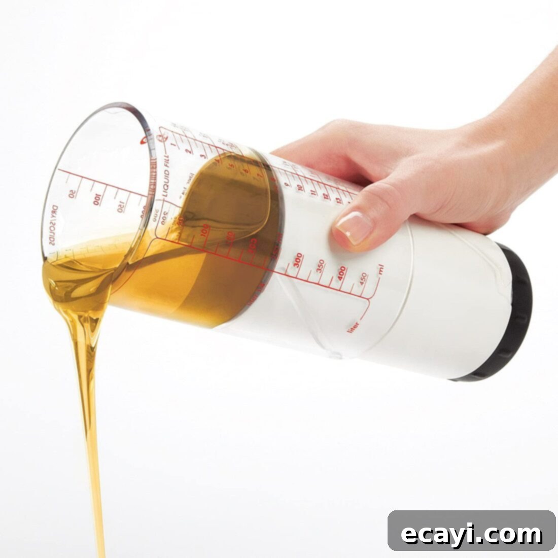21 Kitchen Gadgets You'll Reach For Daily 7 Thick honey being dispensed from an adjustable measuring cup, demonstrating its effectiveness with sticky ingredients.