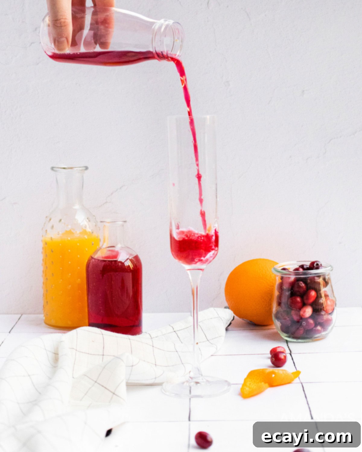 Sparkling Cranberry Mimosa 3 Pouring pure cranberry juice into a champagne flute