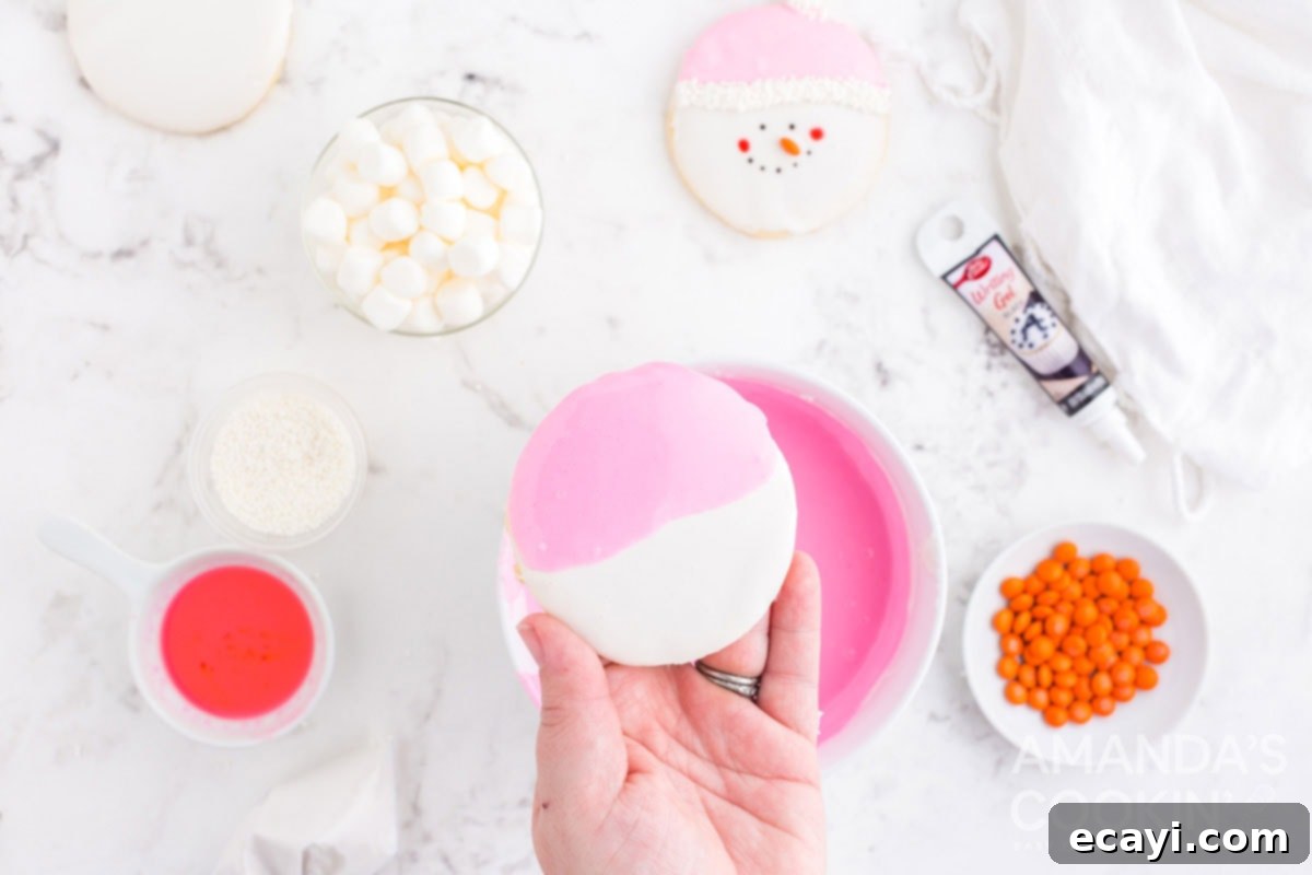 Sweet & Simple Decorated Cookies 13 A round cookie half-dipped in pink frosting over a white base, creating a snowman's cap effect.