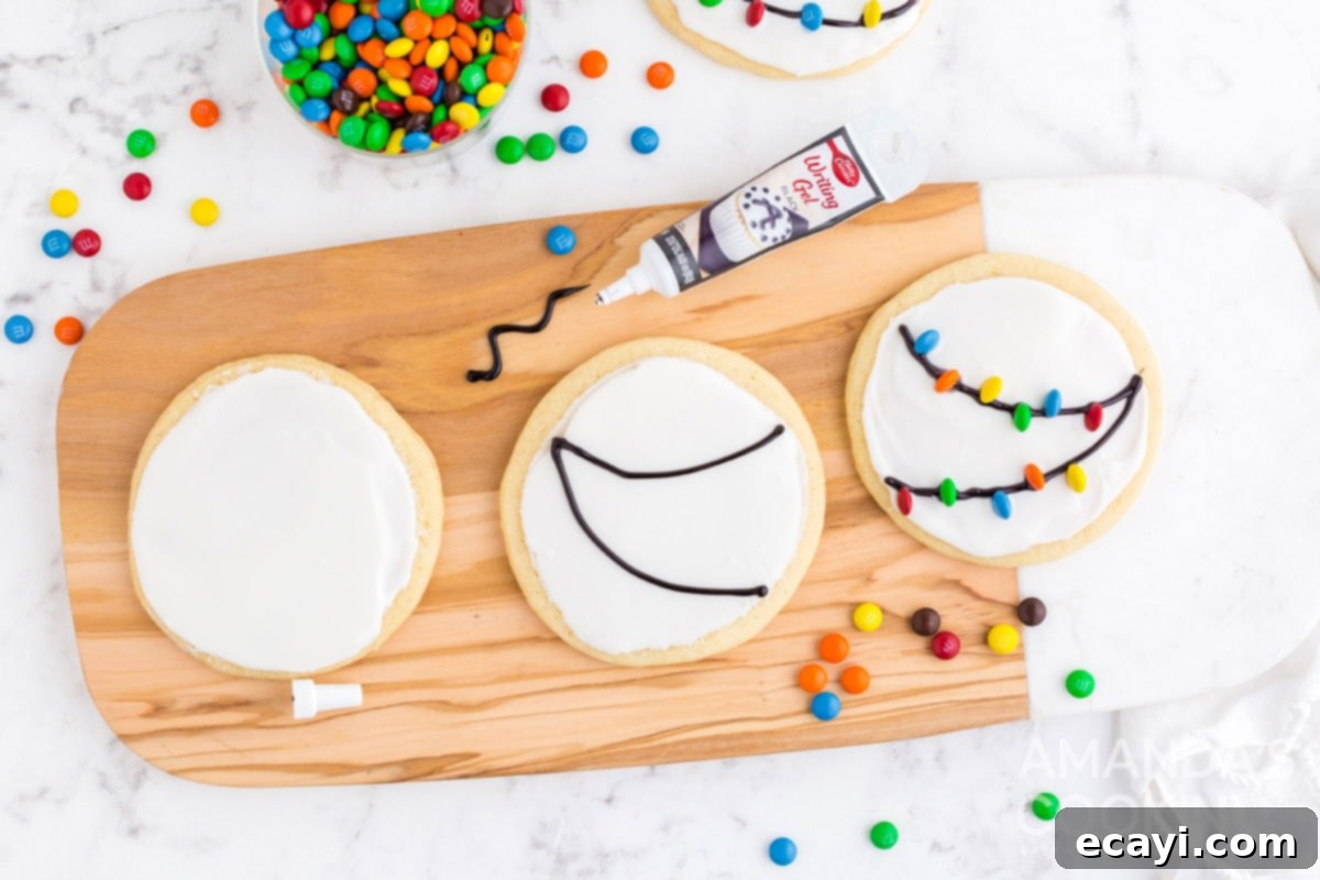 Sweet & Simple Decorated Cookies 9 A hand piping black writing gel in swag patterns onto white iced sugar cookies to create Christmas light strings.