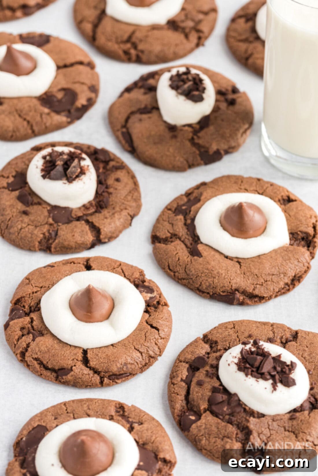 Cozy Cocoa Cookies 15 A beautifully decorated hot cocoa cookie with melted marshmallows and chocolate served on a plate with a tall glass of milk.