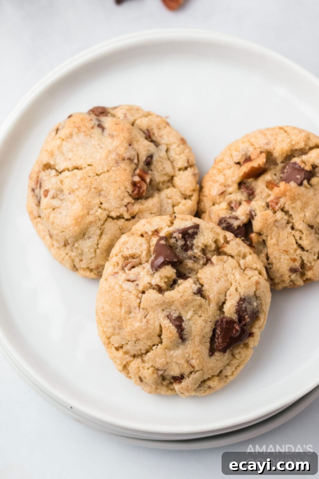 Legendary Neiman Marcus Cookies 3 A plate piled high with golden brown Neiman Marcus cookies, ready to be enjoyed.