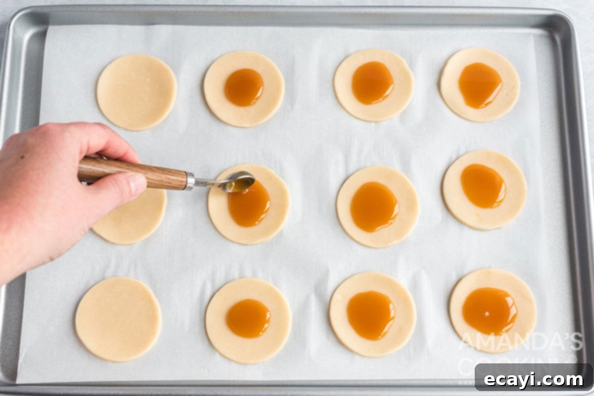 Apple Pie Delights 7 adding a small dollop of caramel sauce to the center of a round pie dough cut-out