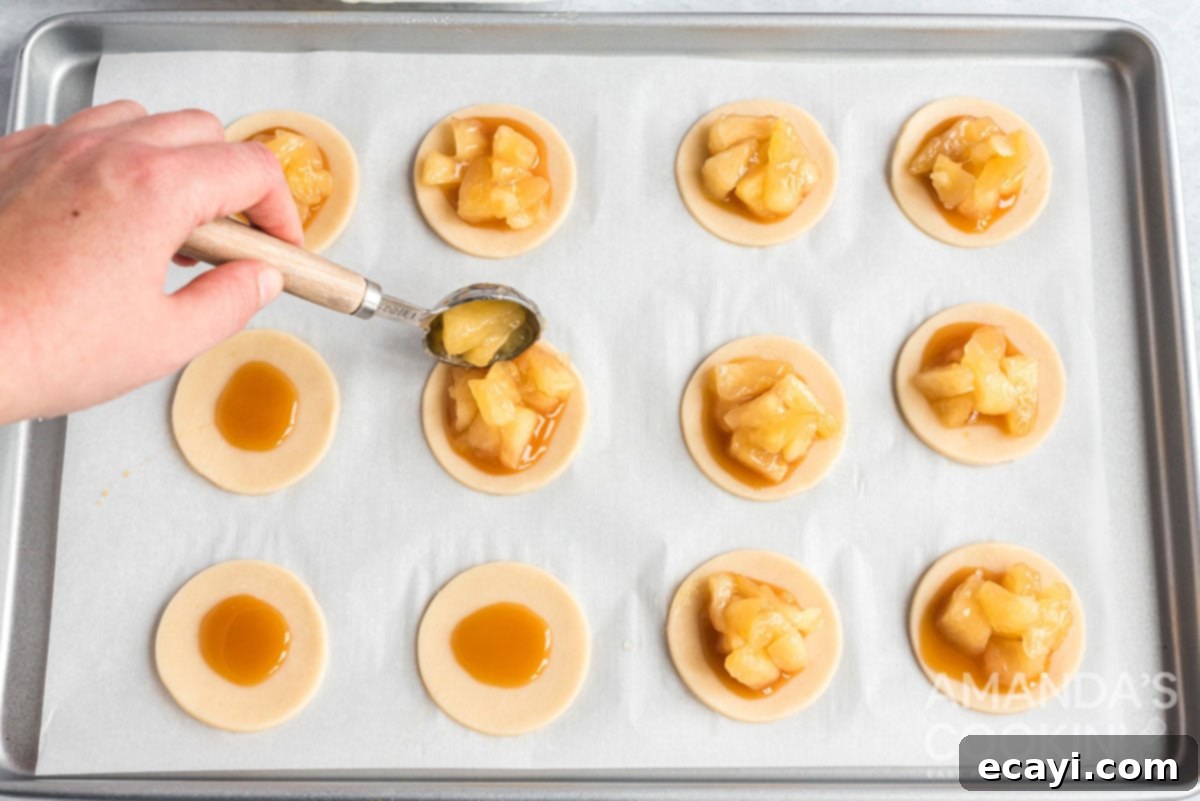 Apple Pie Delights 8 adding a spoonful of chopped apple pieces on top of the caramel layer on a pie dough base