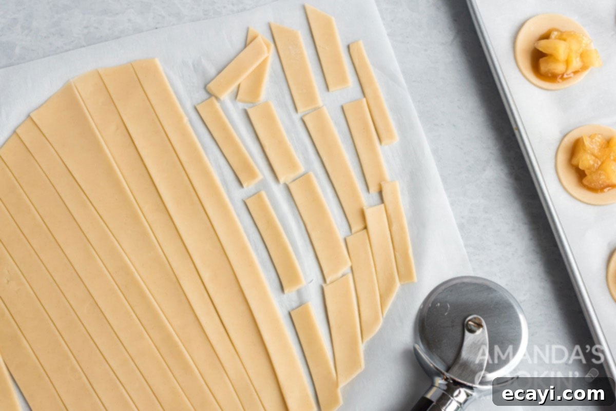 Apple Pie Delights 9 pie dough neatly cut into strips of varying lengths, prepared for the cookie topping