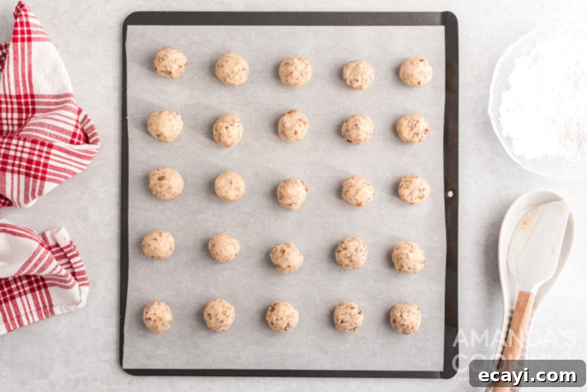 Snowball Cookies 10 Unbaked cookie dough balls sitting on a baking sheet, ready to be placed into the oven